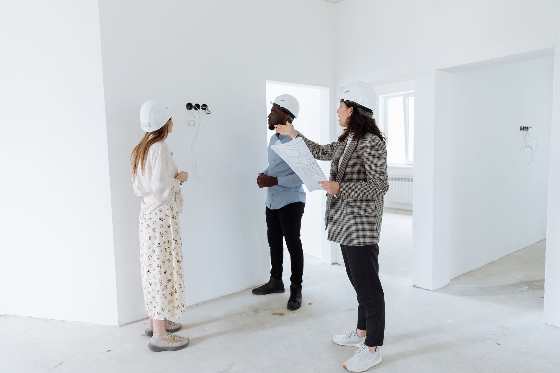 Conseiller expliquant les aides à la rénovation énergétique à des propriétaires dans un logement en travaux