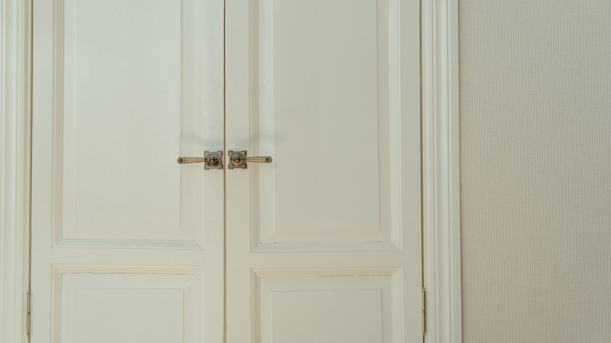 Porte double blanche élégante avec poignées en laiton, illustrant une porte bien sécurisée