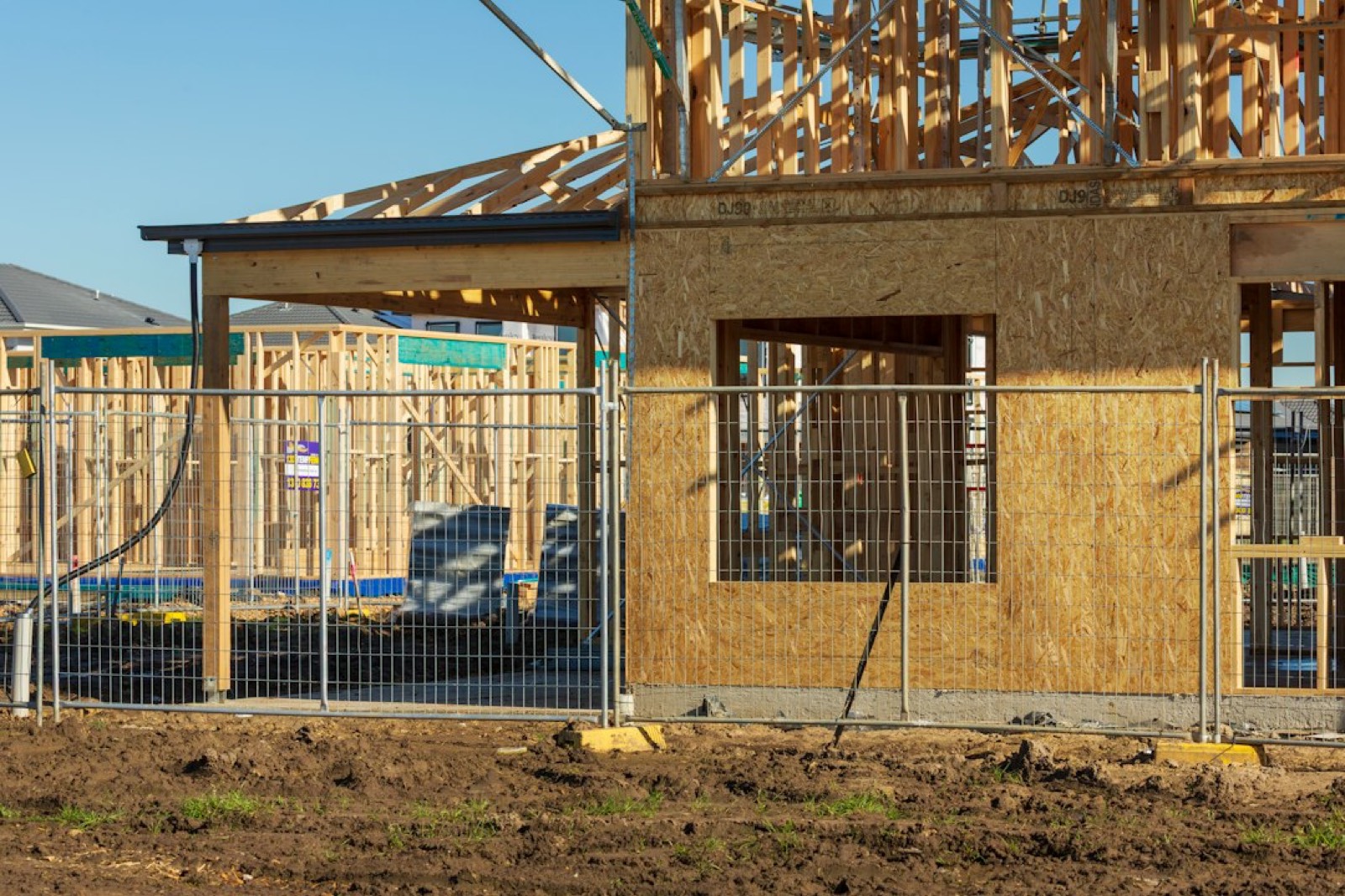 Panneaux de clôture mobile posés sur plots devant une maison en rénovation