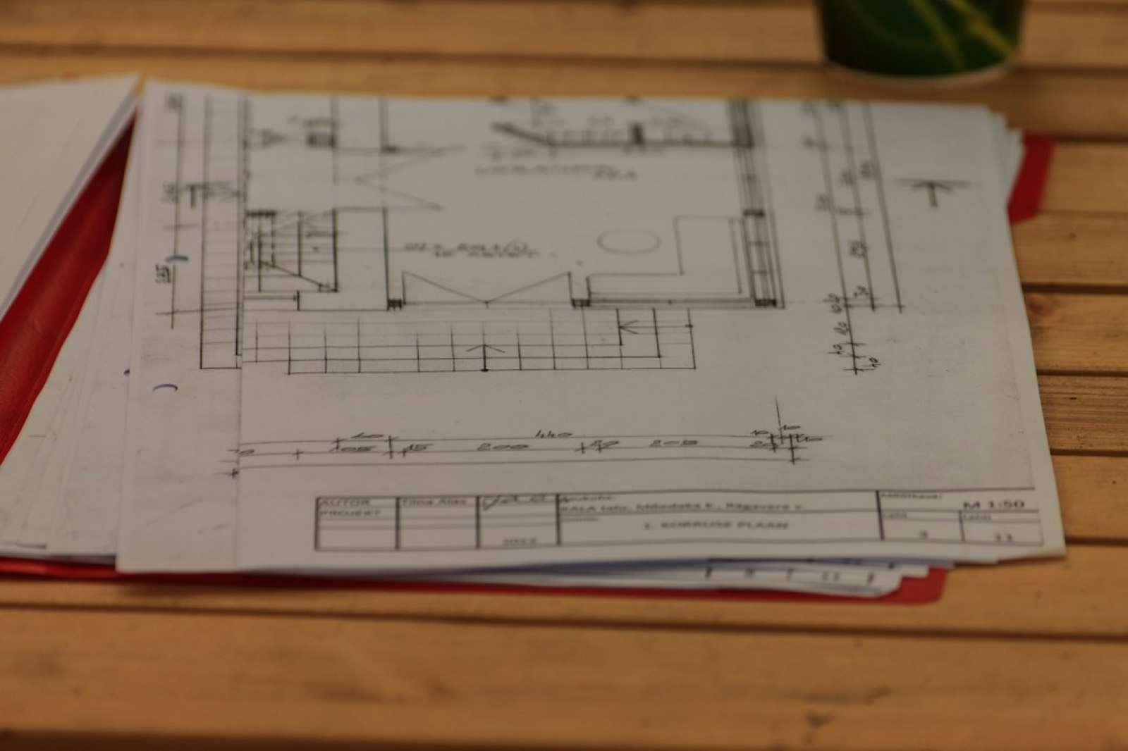 Plans d'extension de maison déployés sur une table pour le dossier de permis de construire
