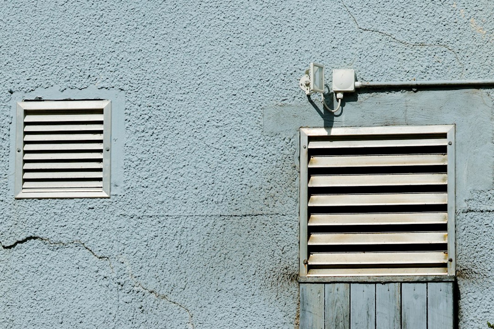 Grille d'aération murale dans une pièce où fonctionne un appareil de chauffage